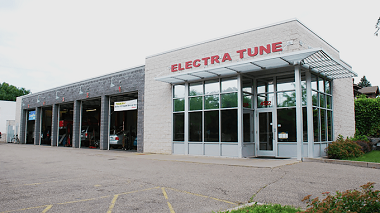 Electra Tune Tire & Auto building and service garage with cars shown inside the service bay area showcasing this provider as a trusted automotive service provider for vehicles, including import car repair, in Minneapolis, MN